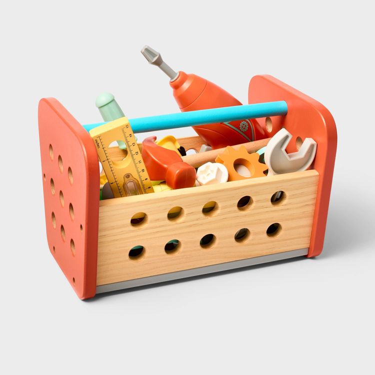 Wooden toy toolbox with orange colored sides, containing various colorful toy tools including a ruler, wrench, and screwdriver.