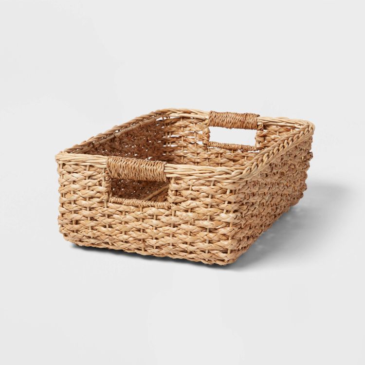 Rectangular woven basket with two handles, made of natural colored material.