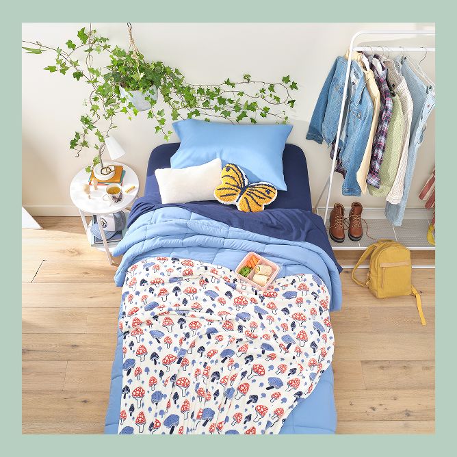Blue bed sheets with mushroom covers and a butterfly pillow.
