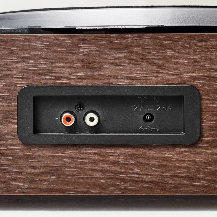 Close-up of a wooden turntable showing the back panel with red and white audio output jacks labeled "LINE OUT" and a DC IN port labeled "12V 2.5A."