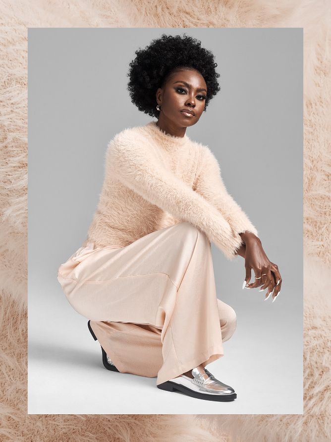 Gezelle Renee is going monotone with peachy beige styles that allow textures to be the focus. A soft and fuzzy textured sweater is paired with flowy, silky dress pants and shiny silver loafers. 