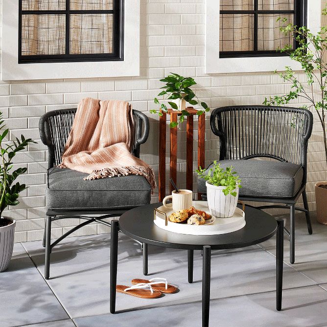 Outdoor seating area with black chairs and coffee table. 