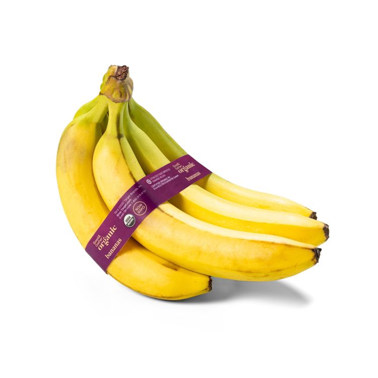 A bunch of yellow colored bananas with a purple label that reads "Organic bananas."