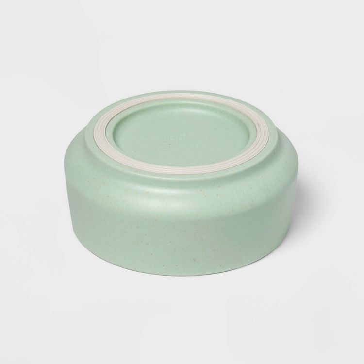 A light green colored bowl shown upside down on a white background.