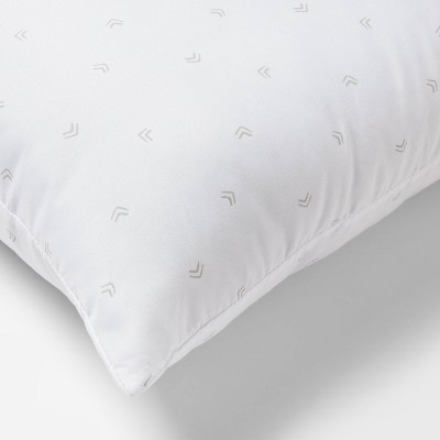 White bed pillow with a subtle pattern of small gray colored chevrons.