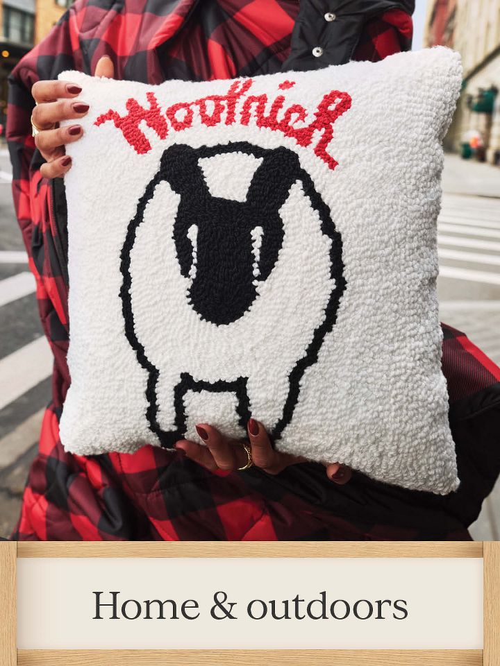 Home & outdoors– 
image features a plush white pillow with nostalgic sheep graphic and woolrich logo.