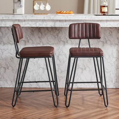 Two brown PU leather bar stools with backrests in front of marble bar