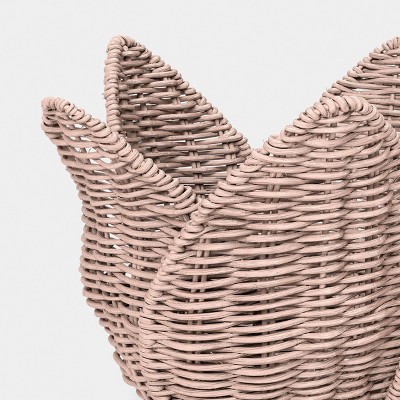 A close-up of a light brown colored woven basket with a textured, curved design.