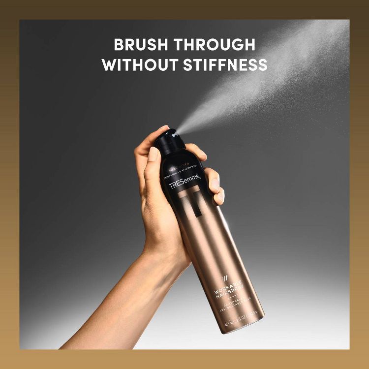 A hand holding a bronze colored can of TRESemmé Workable Hairspray with text "BRUSH THROUGH WITHOUT STIFFNESS" above.