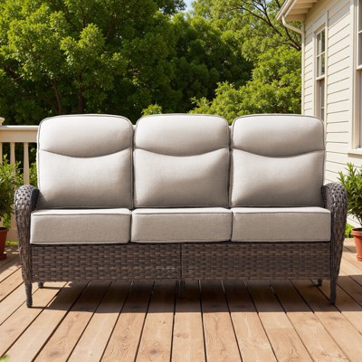Three-seat wicker outdoor sofa on a wooden deck