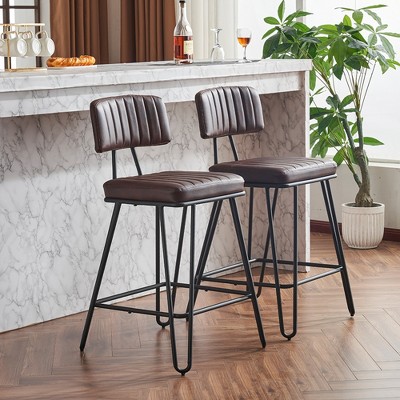 Two brown PU leather bar stools with backrests near marble bar