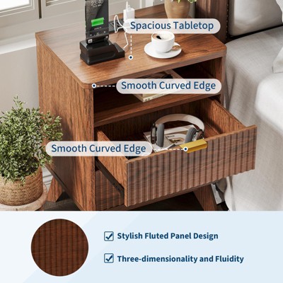Wooden nightstand with a spacious tabletop, smooth curved edges, an open shelf, and a drawer partially open containing headphones, featuring a stylish fluted panel design.