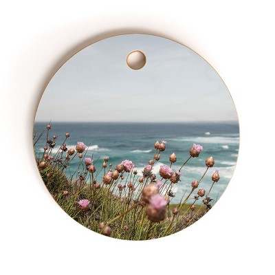 Henrike Schenk - Travel Photography Pink Flowers by the Ocean Cutting Board Round - Deny Designs
