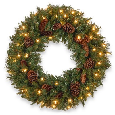 National Tree Company Pre-Lit Artificial Christmas Wreath, Green, Evergreen, White Lights, Decorated with Pine Cones, Christmas Collection, 24 Inches