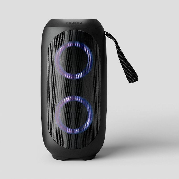 Black colored portable speaker with two illuminated circular lights and a carrying strap on the side.