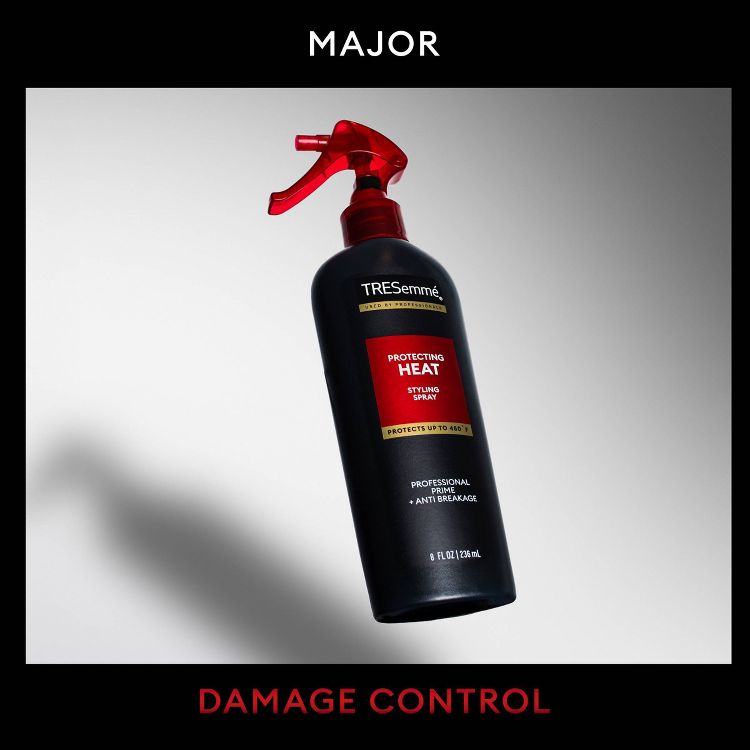 Black colored spray bottle with red nozzle labeled "TRESemmé Protecting Heat Styling Spray" and "8 FL OZ (236 mL)."
