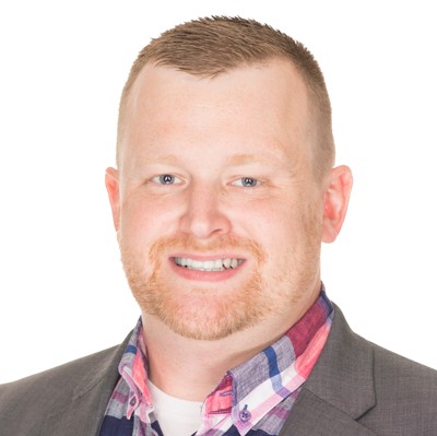 Target Principal Cybersecurity Analyst Terry Woodman, wearing a plaid button-down shirt and gray jacket, smiling against a white background