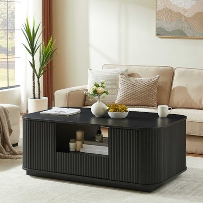 Coffee table in living room with plant and artwork in background