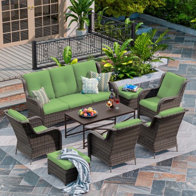 Patio furniture set with green cushions and assorted pillows