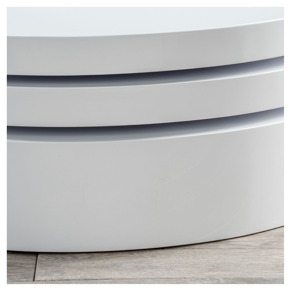 Close-up of base and grooves of white rotating coffee table
