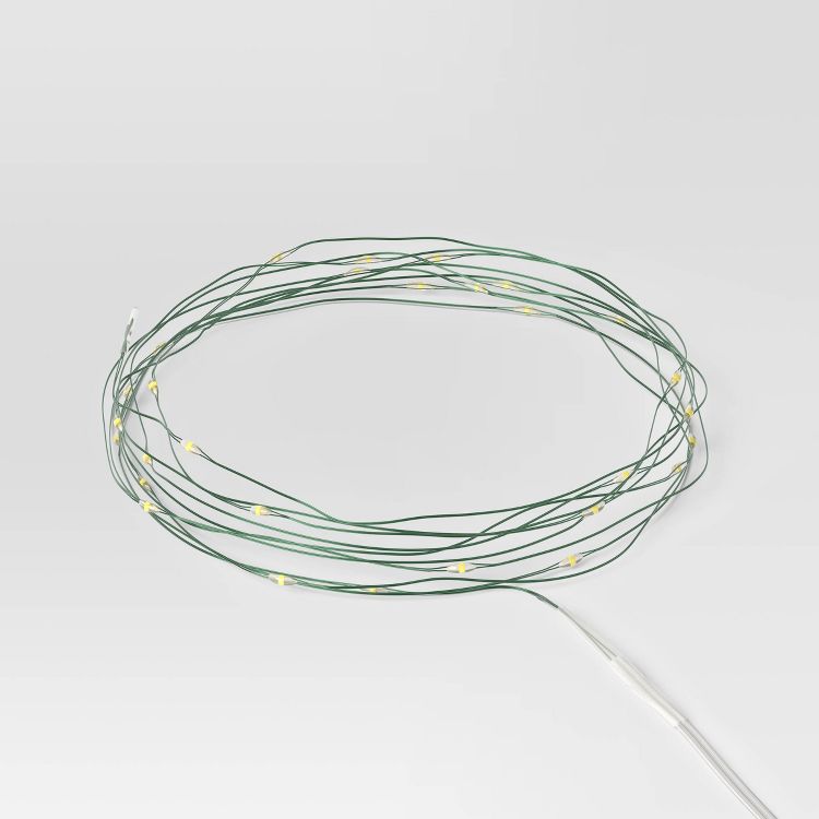 A coil of green wire string lights with small yellow colored LED bulbs.