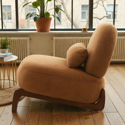 Tan velvet chair with curved wooden base by a window