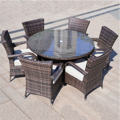 Round glass-top wicker table with six chairs from a top-down angle