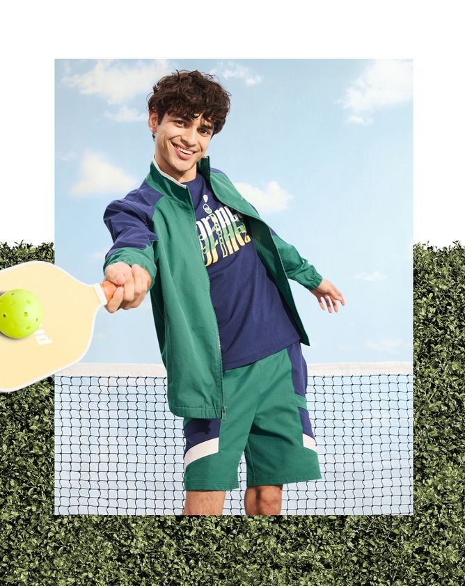 man wearing jacket, shorts & tee from the collection playing pickleball