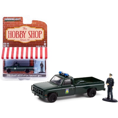 1986 Chevrolet M1008 Pickup Truck Dark Green & Enforcement Officer Figurine "The Hobby Shop" 1/64 Diecast Model by Greenlight