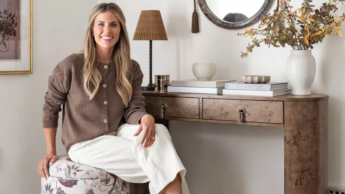 Shea McGee sitting on swivel ottoman in entry
