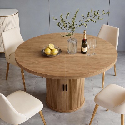 Round wood dining table with ribbed pedestal base seen from a slightly top angle