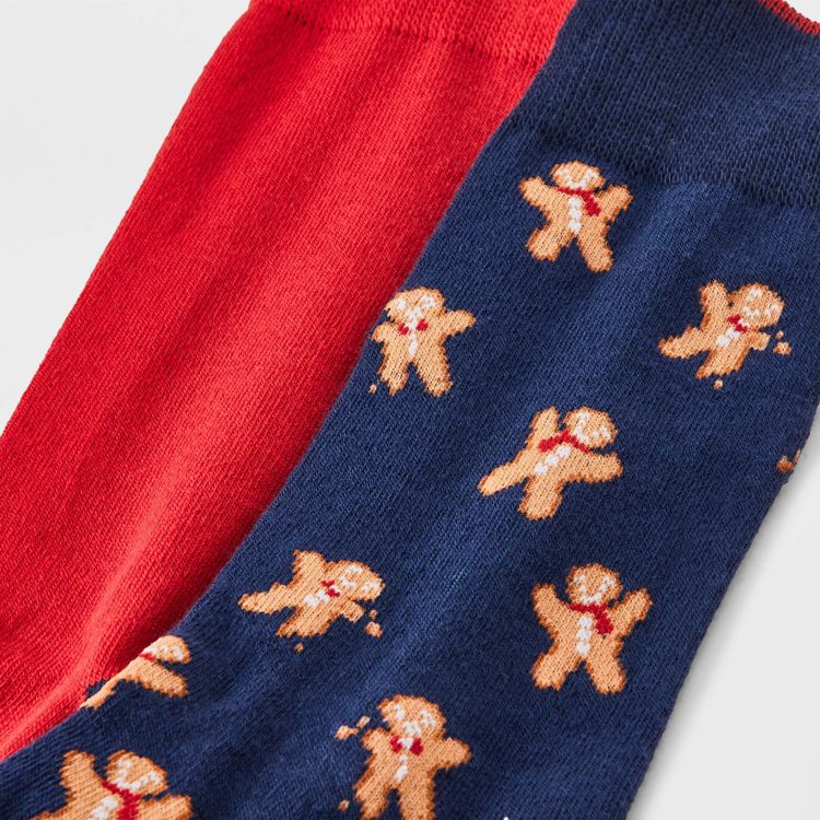 Two socks, one red colored and the other navy blue colored with gingerbread man patterns.