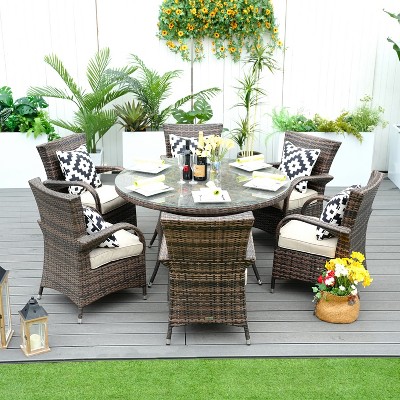 Six-person outdoor wicker dining set on a deck with cushions and tableware