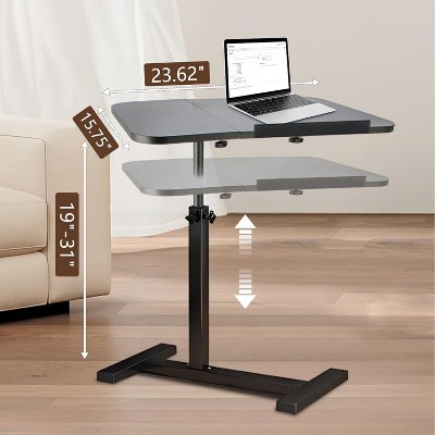Adjustable overbed table with two-tier surface and wheels on a pedestal stand.