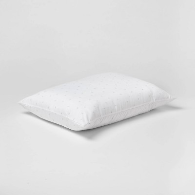 A white rectangular pillow with a subtle dotted pattern on a plain background.