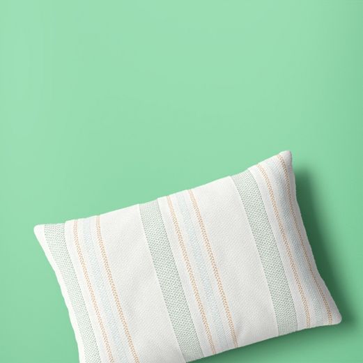 Throw pillow with orange and green accent lines on a white base