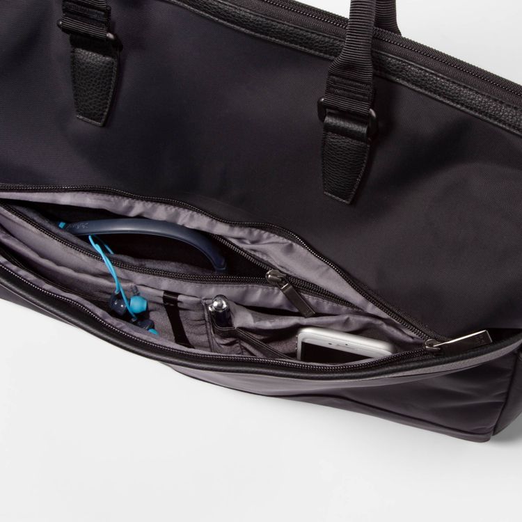 Black colored bag with multiple compartments, containing blue earphones, a pen, and a smartphone.