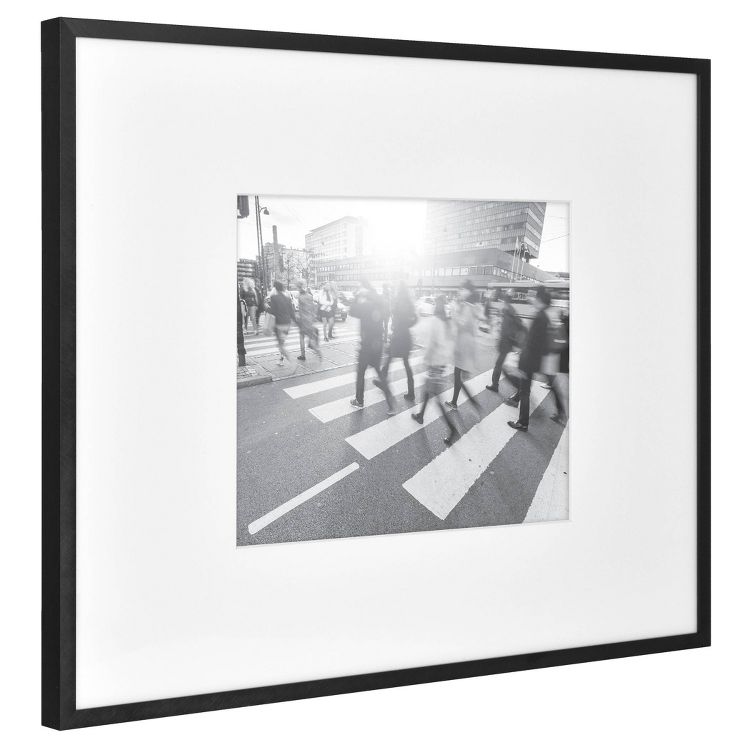 A black frame with a black and white photograph of people crossing a street at a crosswalk.