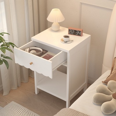 White kid-sized nightstand with one open shelf and a partially open drawer