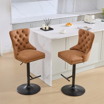 Set of two modern upholstered bar height swivel stools with tufted backs and studded accents, height adjustable
