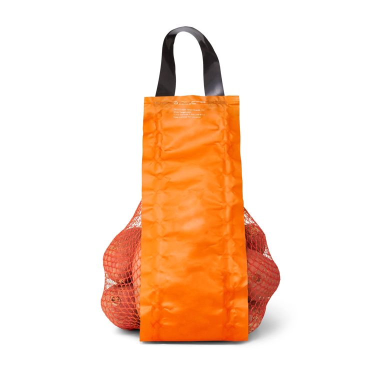 A mesh bag filled with potatoes, partially covered by an orange colored label with a black handle.