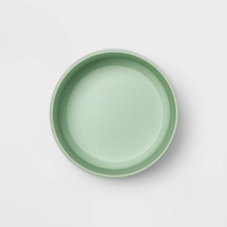 A round, light green colored bowl viewed from above on a white background.