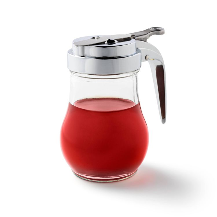 A glass syrup dispenser filled with red colored syrup and a metal lid with a handle.