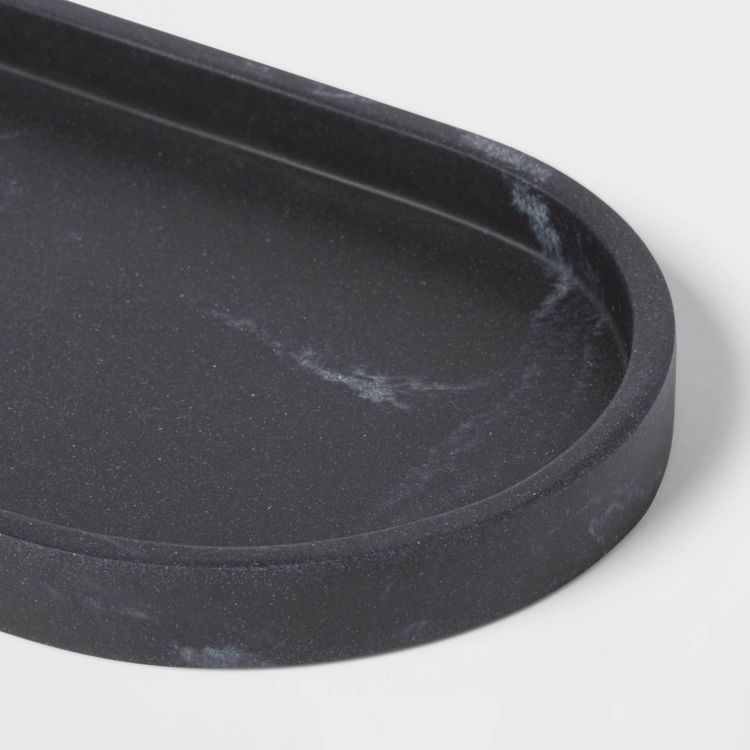 A black colored tray with a marbled pattern and rounded edges.