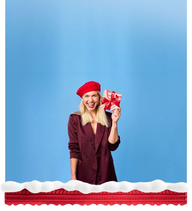 Woman holding a gift box and smiling at camera