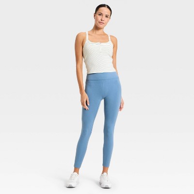 A white and light green striped sleeveless top with a scoop neckline and button detail.