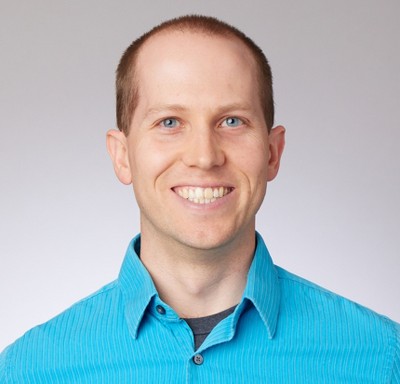 Headshot of Cole Stiegler, a white man with short blonde hair in a light blue button-up shirt.