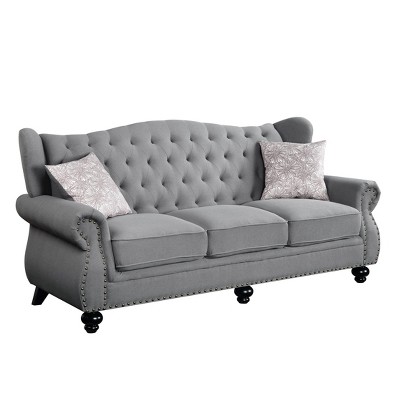 Gray Fabric Camelback Sofa with Floral Cushions and Nailhead Trim