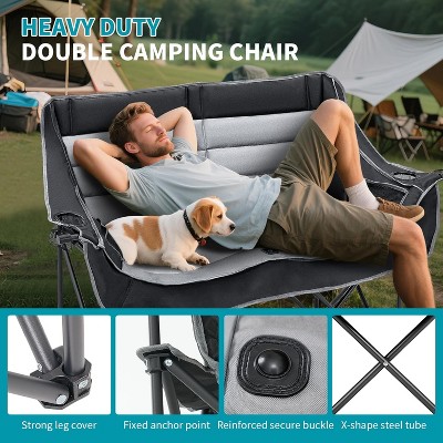 Person lying on double camping chair with a dog beside