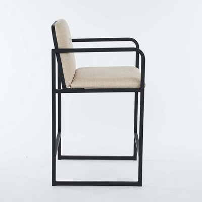 Side profile of beige upholstered bar stool with black frame